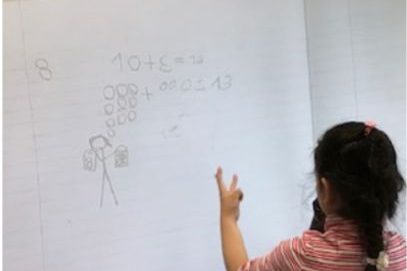 Child sharing her math notebook the class